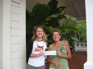 REEF Executive Director Leda Cunningham accepts a check from events volunteer Evelyn McGlone.: Photo by REEF.